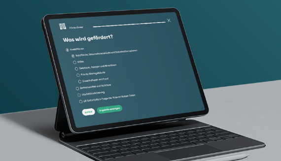 Mit wenigen Klicks zum passenden Förderkredit Ein Tablet mit Tastaturhülle steht auf einem Tisch. Auf dem Bildschirm ist eine Webseite mit dem Titel 'Was wird gefördert?' zu sehen. Darunter befinden sich mehrere Auswahlkästchen mit verschiedenen Fördermöglichkeiten, wie Kraftfahrzeuge, Ställe, private Wohngebäude und weitere. Am unteren Bildschirmrand sind zwei grüne Schaltflächen mit den Beschriftungen 'Zurück' und 'Ergebnisse anzeigen' sichtbar. Der Hintergrund ist einfarbig in dunklem Türkis gehalten.